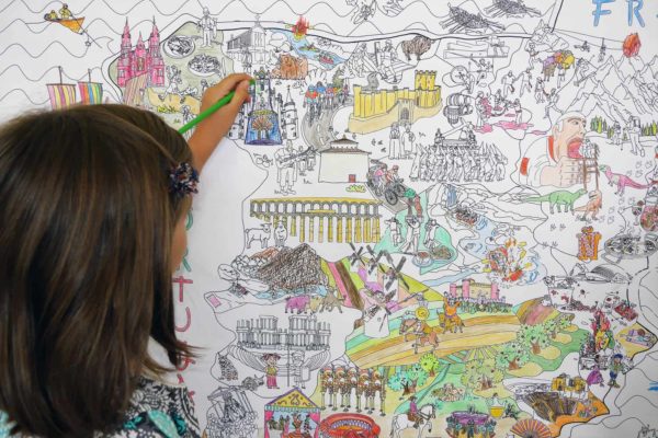 Niña pintando el mapa gigante de España para colorear de Pinta y Pinto
