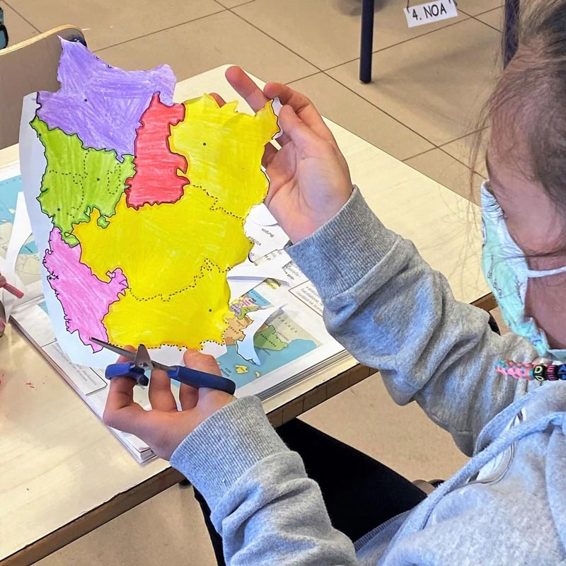 I bambini giocano a mettere insieme tutte le parti di un Paese che hanno ritagliato dai PDF scaricabili. 