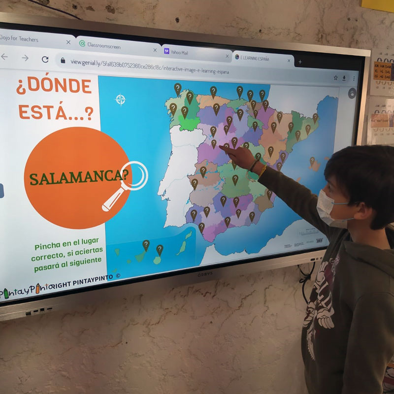 A child in the classroom using an interactive monitor to play a game to identify the autonomous community.